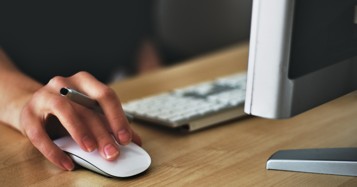 Mulher no computador com uma caneta na mão procurando emprego